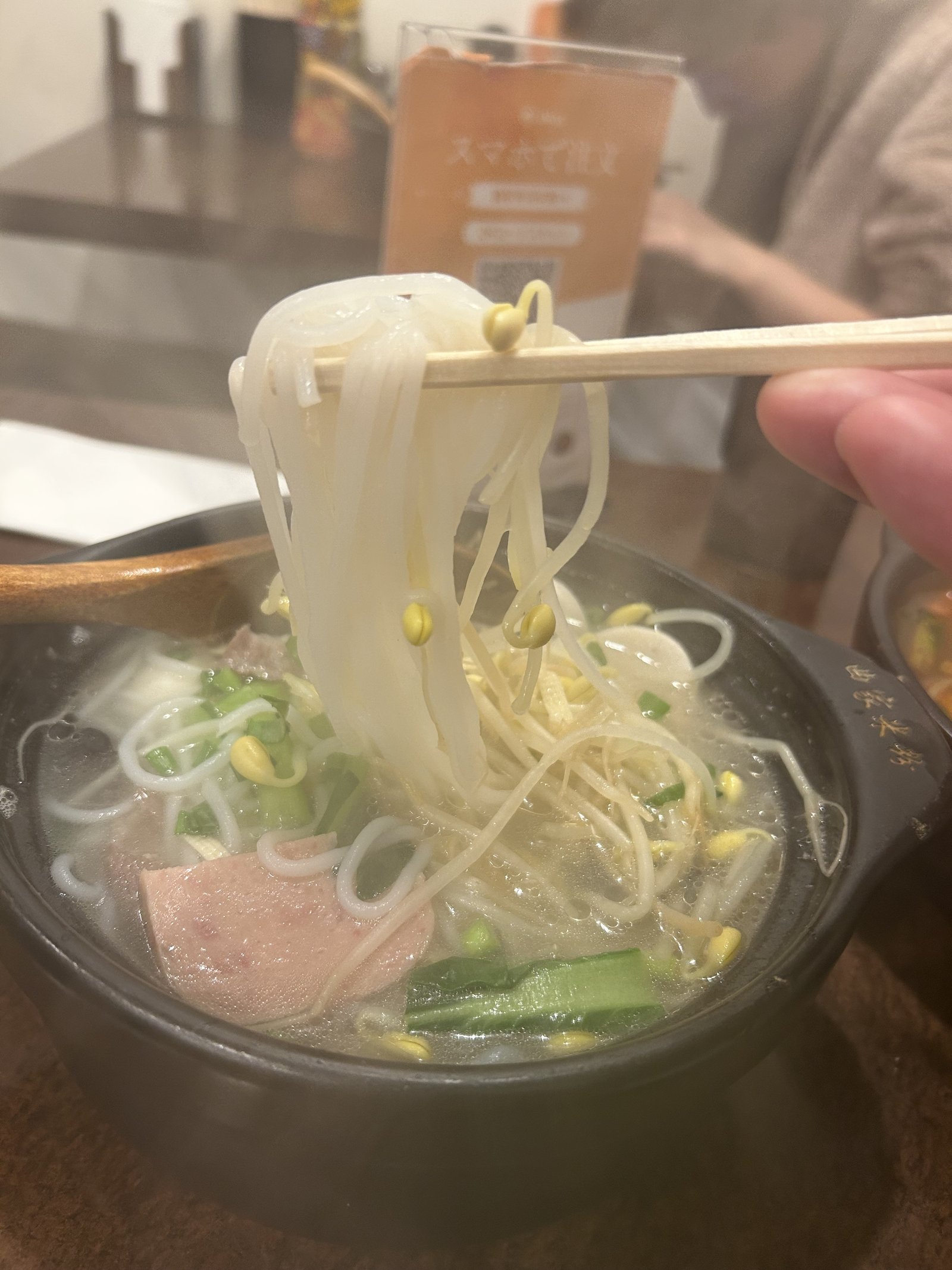 曲家・骨湯米線の麺リフト（白い米線を箸で持ち上げた写真・つるつるとした質感）