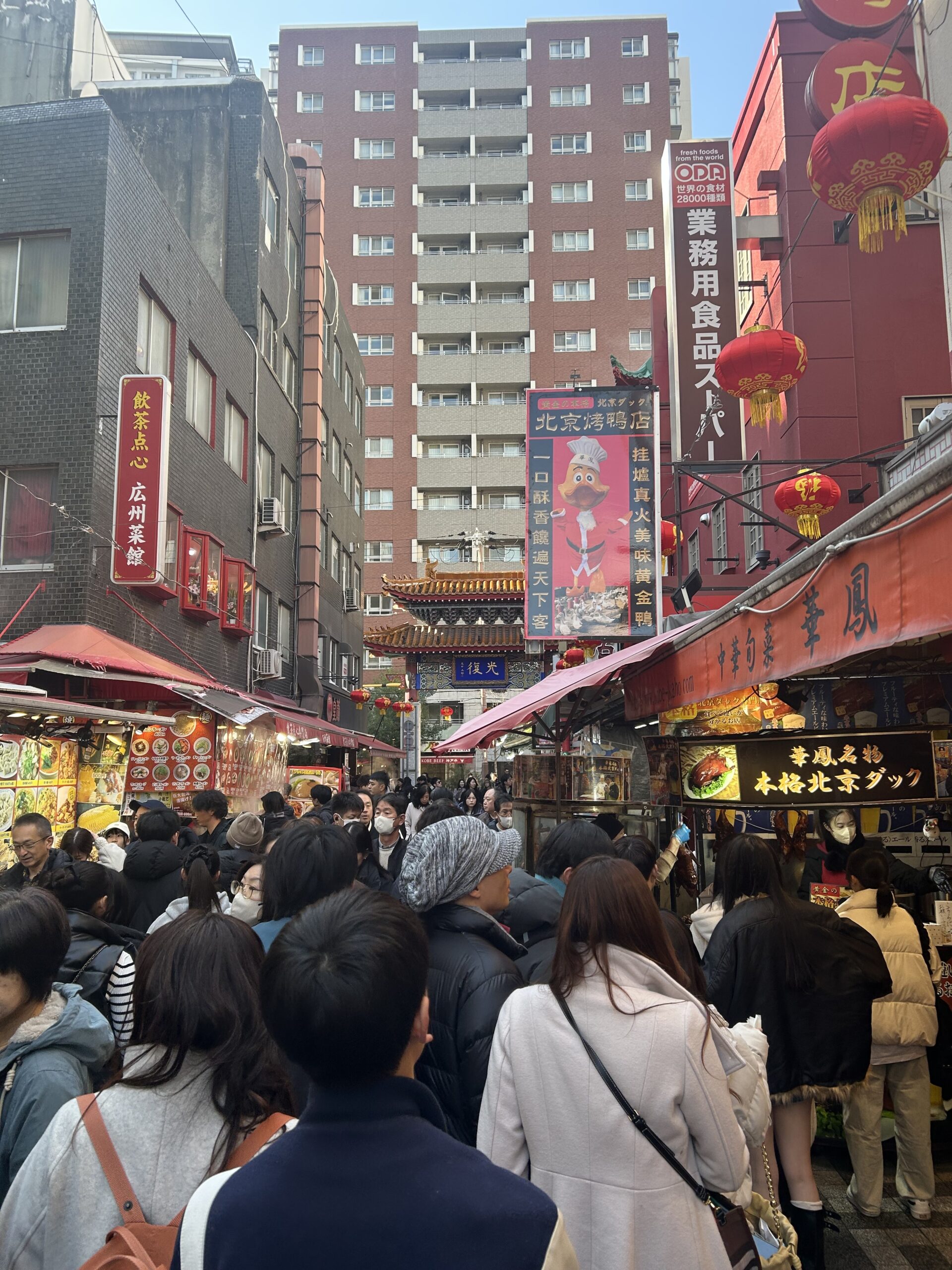 南京町のメインストリートの賑わい・赤い提灯と人混み・食べ歩き客で大混雑