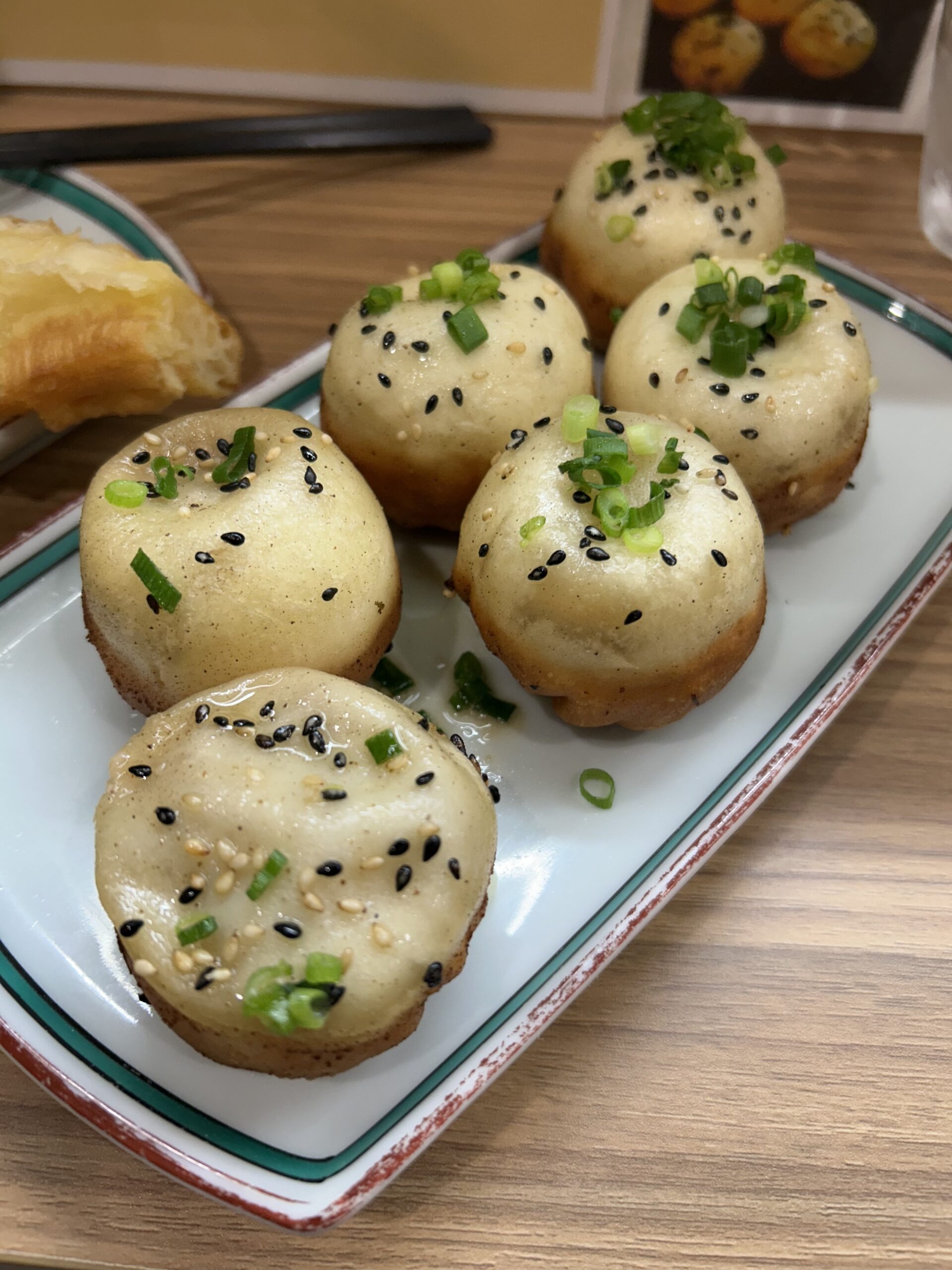 上海焼き小籠包（生煎包）6個。黒ごまと青ねぎがトッピングされた本場上海スタイル