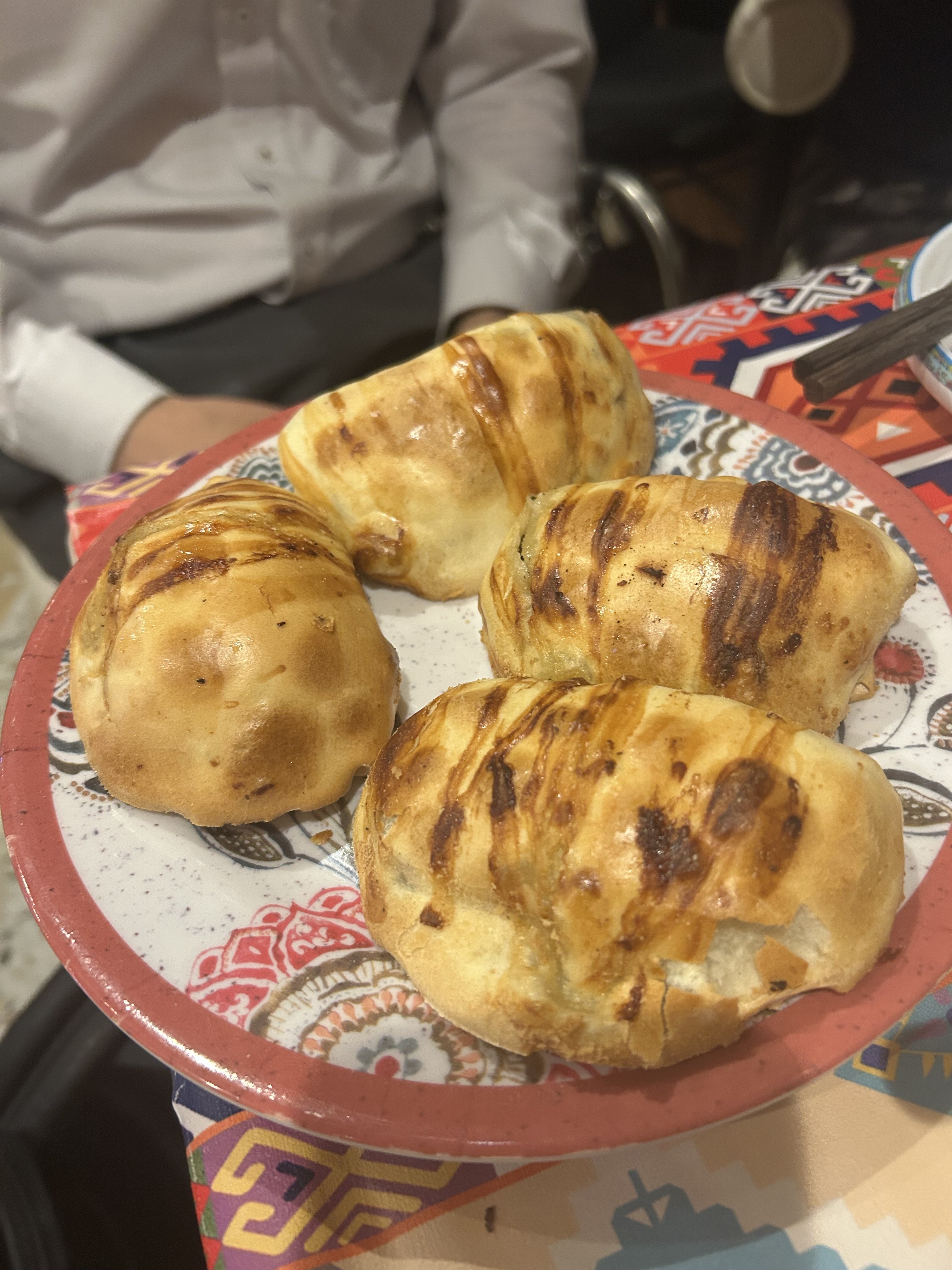 アリババのサムサ。羊肉とタマネギを包んで焼き上げた、表面に焼き目のついたウイグル伝統の焼きパン