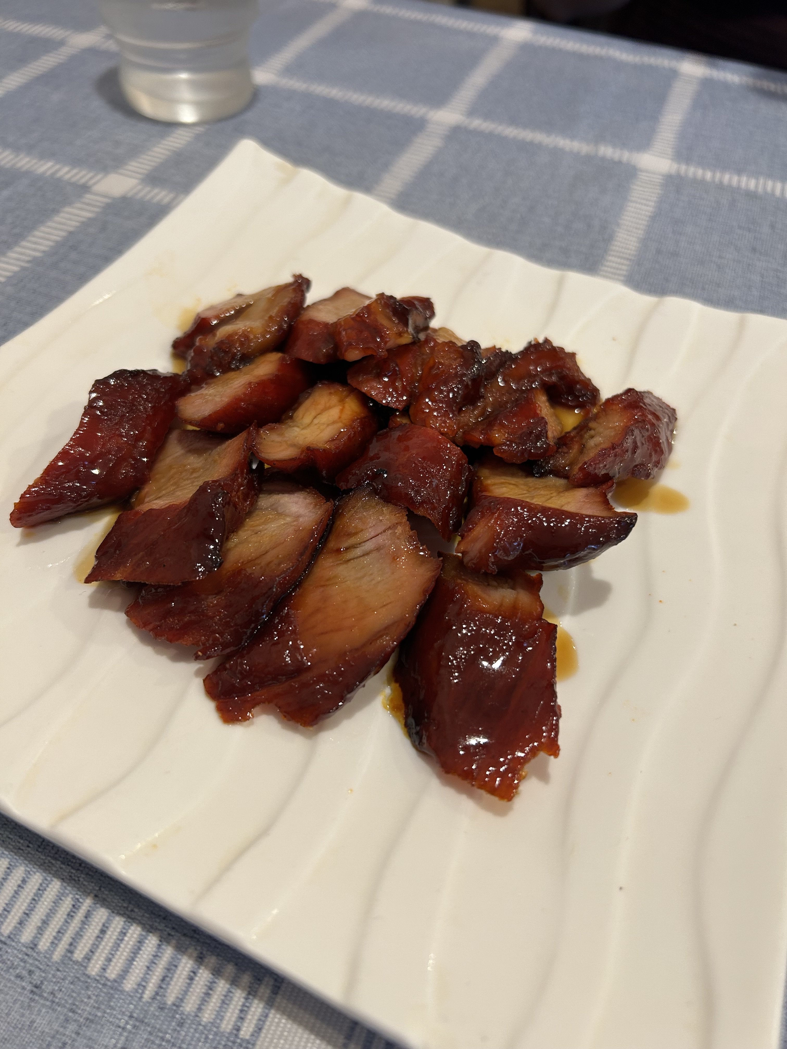 唐家の広式チャーシュー（蜜汁叉焼）。香港風の甘醤油でテリッと光る豚バラのスライス、白い波模様の角皿に盛り付け